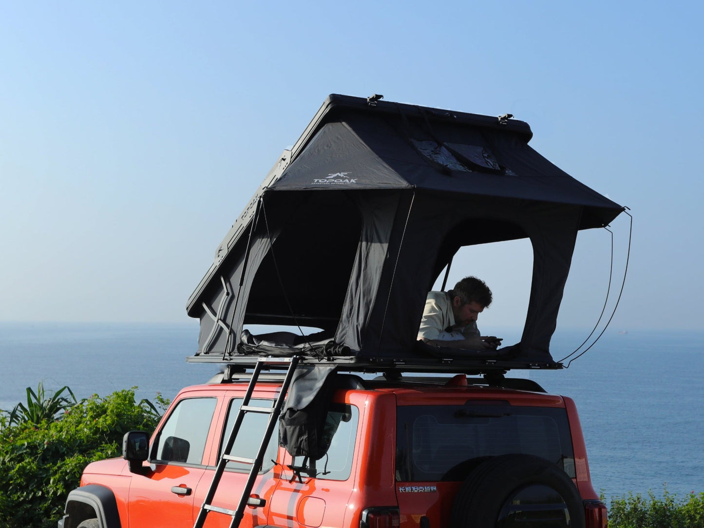 Rear side view TOPOAK Nebula rooftop tent mounted on SUV, hard shell RTT for 4-season camping