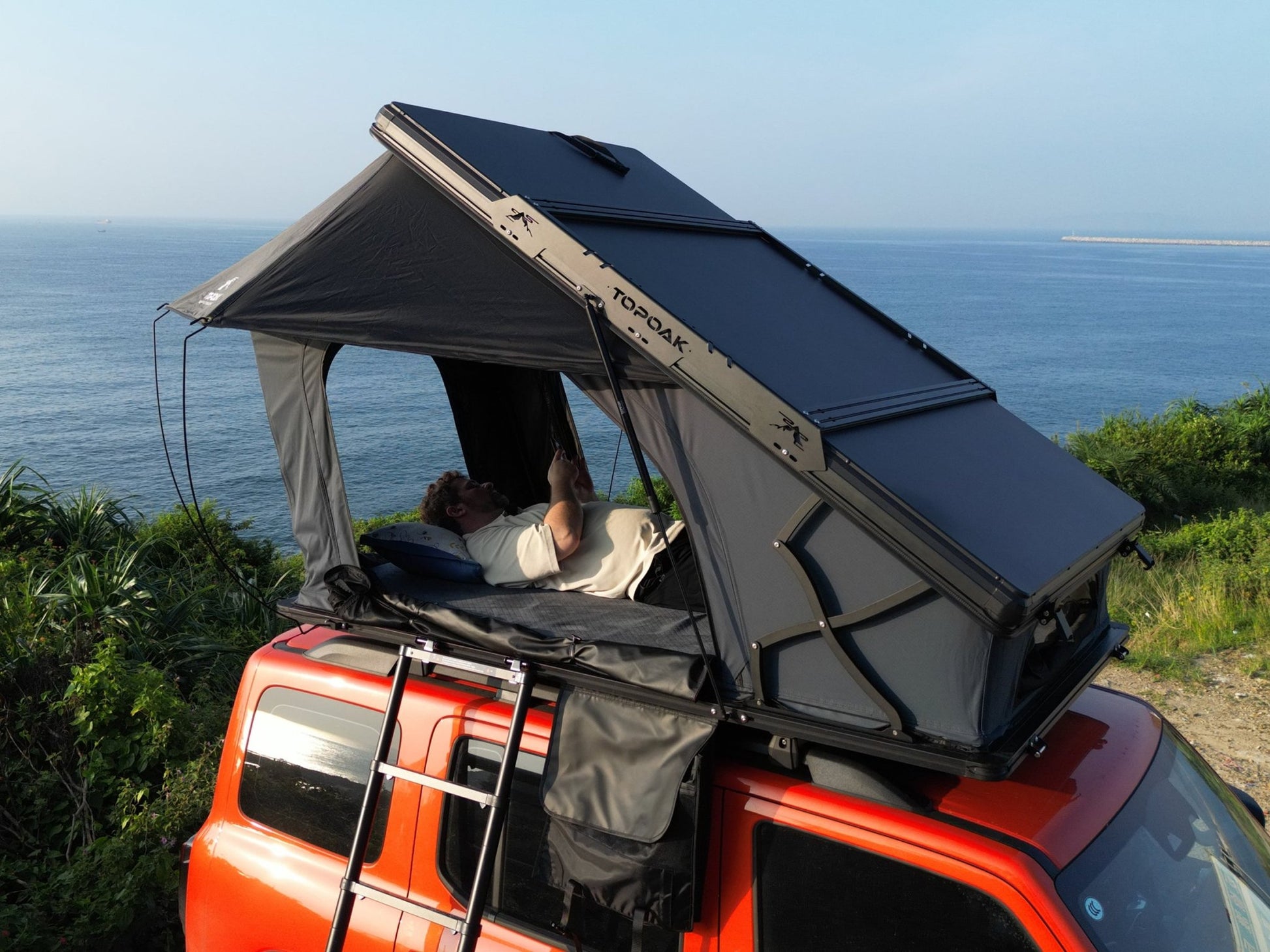 Side top view TOPOAK Nebula rooftop tent mounted on SUV, hard shell RTT for 4-season camping