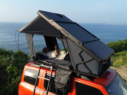 Side top view TOPOAK Nebula rooftop tent mounted on SUV, hard shell RTT for 4-season camping