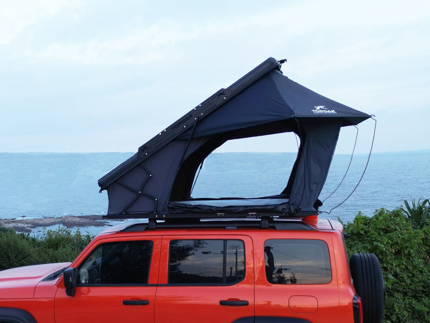 Side view TOPOAK Nebula rooftop tent mounted on SUV, hard shell RTT for 4-season camping