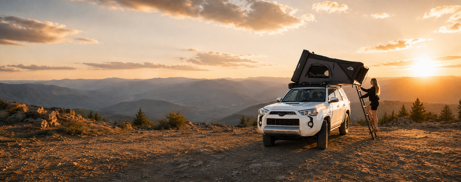TOPOAK hard-shell rooftop tent on a white SUV overlooking the mountains at sunset.